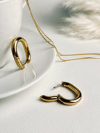 Vera Hoop earrings from the “Timeless Grace” collection displayed side by side — one open and one closed — highlighting their sturdy clasp and smooth 18k gold-plated finish. A modern, timeless design that balances elegance with everyday strength.