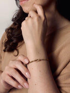 Model wearing Grace Knot gold vermeil bracelet featuring an infinity knot design, delicate everyday jewelry.