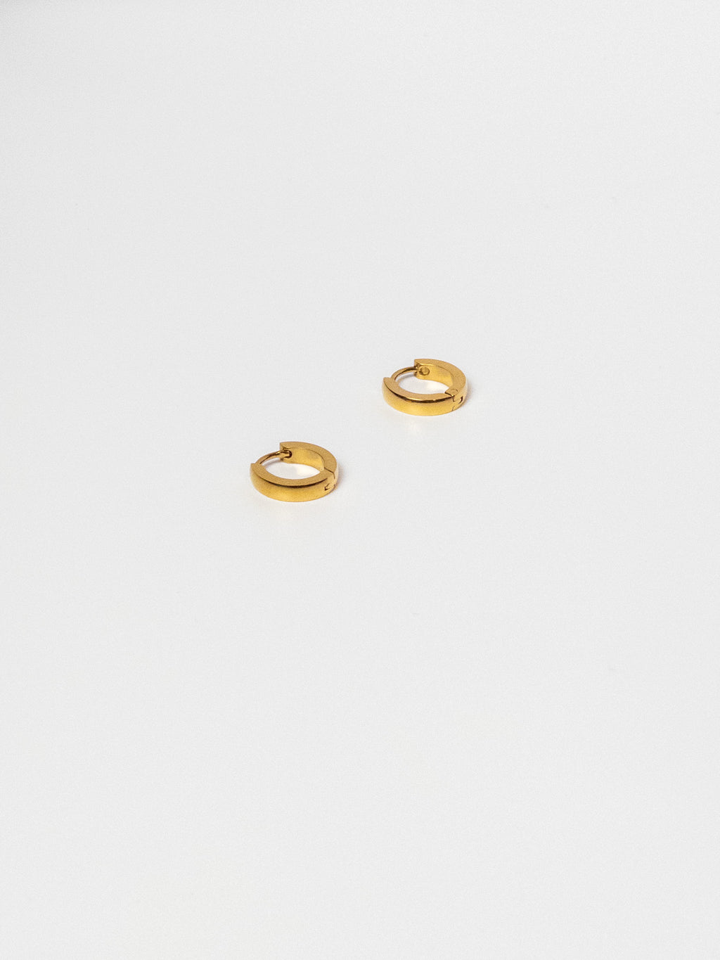 Ease Hoop Earrings displayed in a flat lay, featuring minimalist gold hoop earrings for everyday wear.