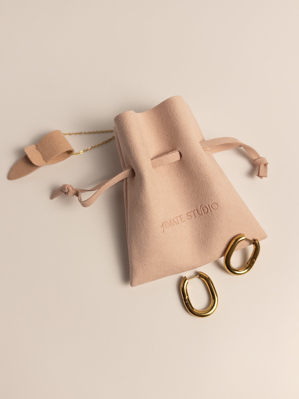 Amate Studio jewelry packaging with microfiber pouch, earrings and necklace showing everyday jewelry packaging.