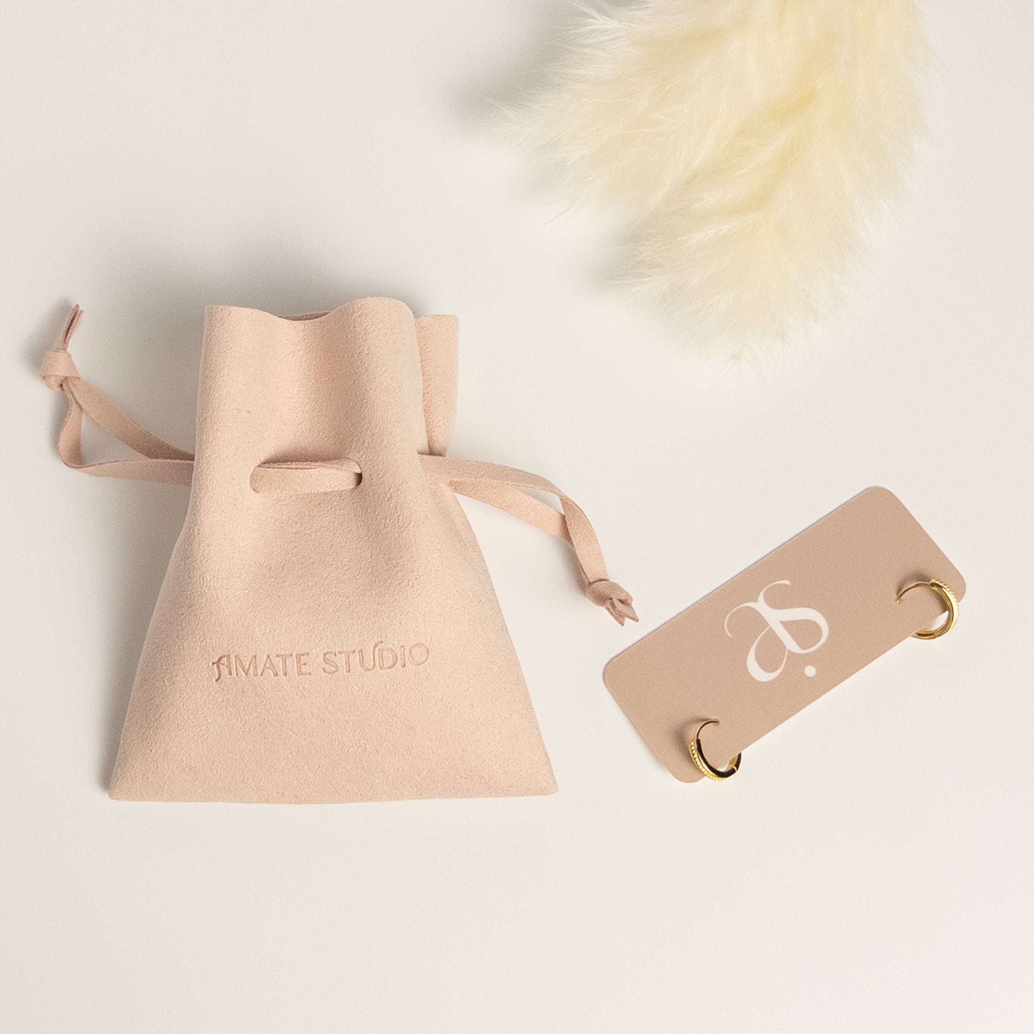 Grace Thread rope hoop earrings packaging showing earrings on display card and Amate Studio branded microfiber pouch