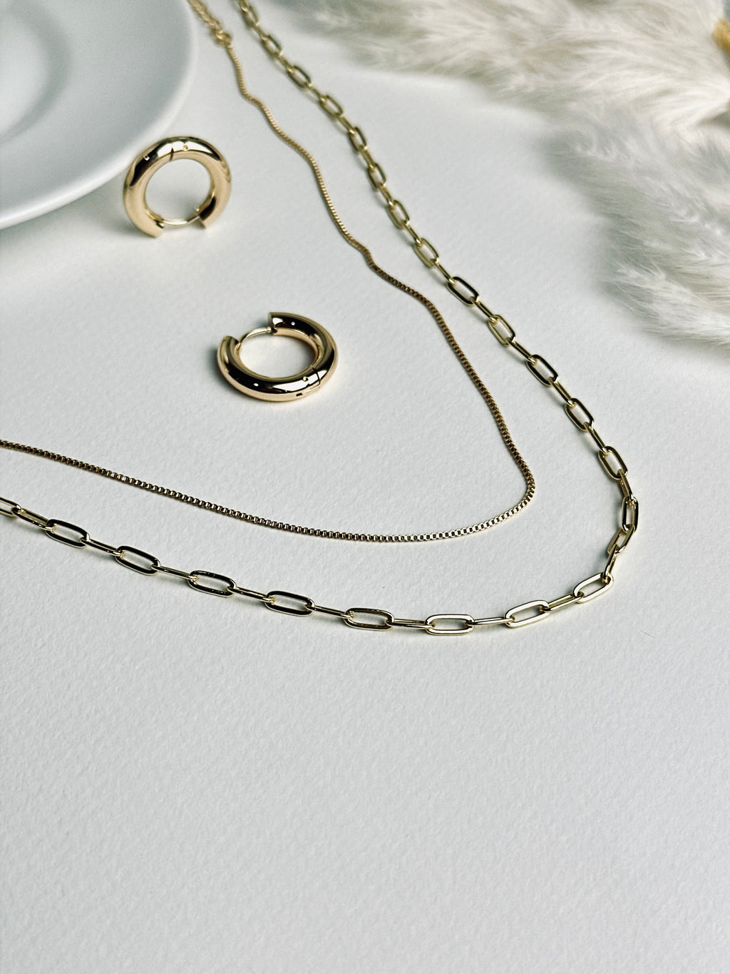 Radiance Hoop earrings from the “Timeless Grace” collection paired with layered gold necklaces. The 20mm thick hoops harmonize with the delicate layers, creating a look of effortless elegance, confidence, and timeless sophistication.