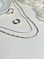 Radiance Hoop earrings from the “Timeless Grace” collection paired with layered gold necklaces. The 20mm thick hoops harmonize with the delicate layers, creating a look of effortless elegance, confidence, and timeless sophistication.