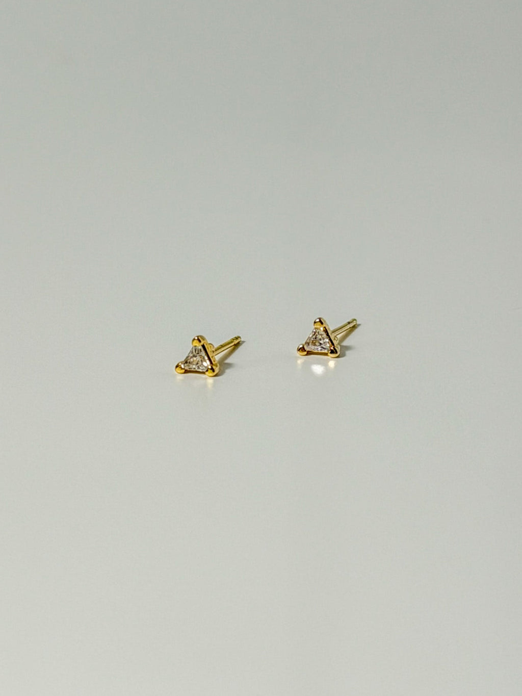 Lucía Studs tiny triangle CZ stud earrings in a flatlay