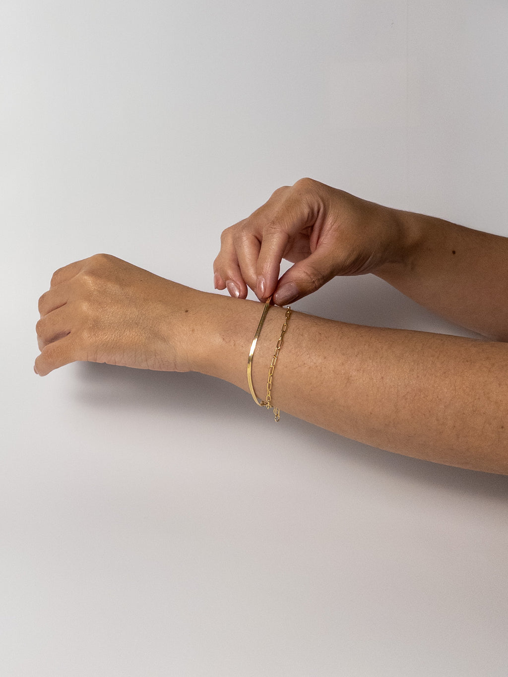 Model wearing the Lumen Bracelet, a minimalist 18k gold filled snake chain bracelet from the Weightless Collection, styled for everyday wear.