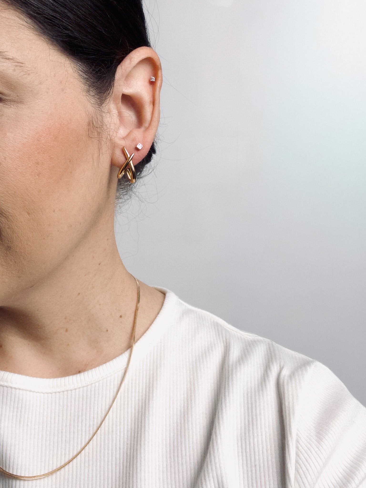 Close-up of a model wearing Amate Studio Lumen Studs and Lumen Chain necklace in 18k gold filled jewelry, styled for a lightweight and minimalist everyday look.