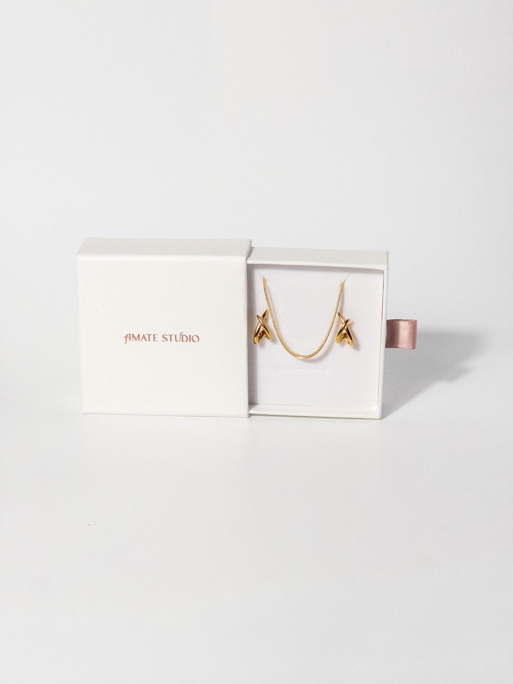 Amate Studio Lumen Studs and Lumen Chain necklace displayed in a fully opened drawer-style jewelry box, showcasing the 18k gold filled jewelry and premium packaging presentation.