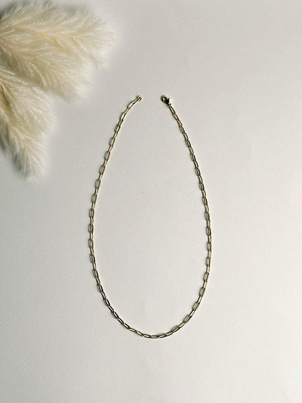 Gloria – Gold Paperclip Necklace from the Timeless Grace collection, an 18k gold-filled 16-inch chain. The delicate links catch the light, reflecting timeless elegance and quiet confidence — a reminder to carry your grace with ease and let your inner glow shine.