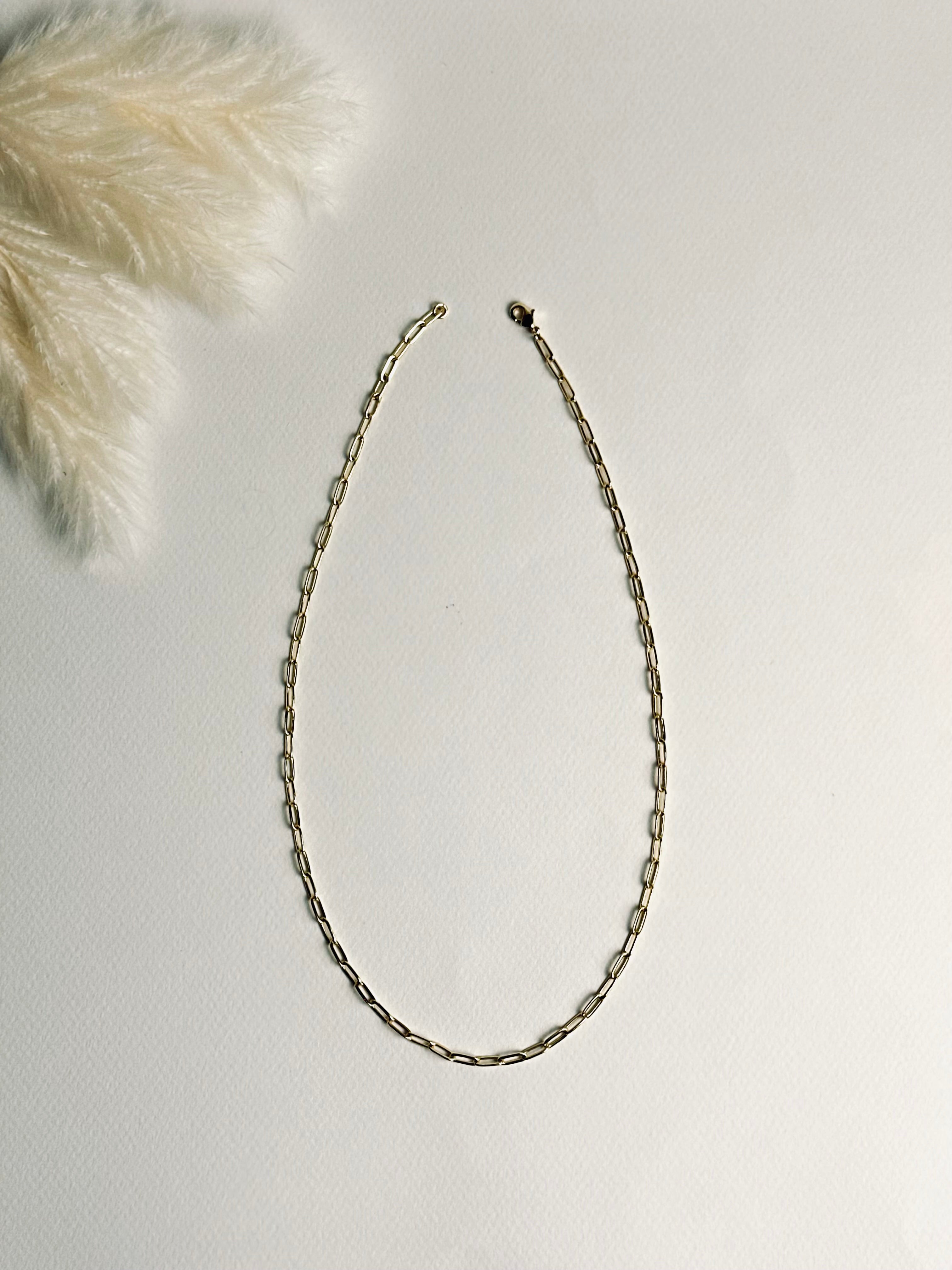 Gloria – Gold Paperclip Necklace from the Timeless Grace collection, an 18k gold-filled 16-inch chain. The delicate links catch the light, reflecting timeless elegance and quiet confidence — a reminder to carry your grace with ease and let your inner glow shine.