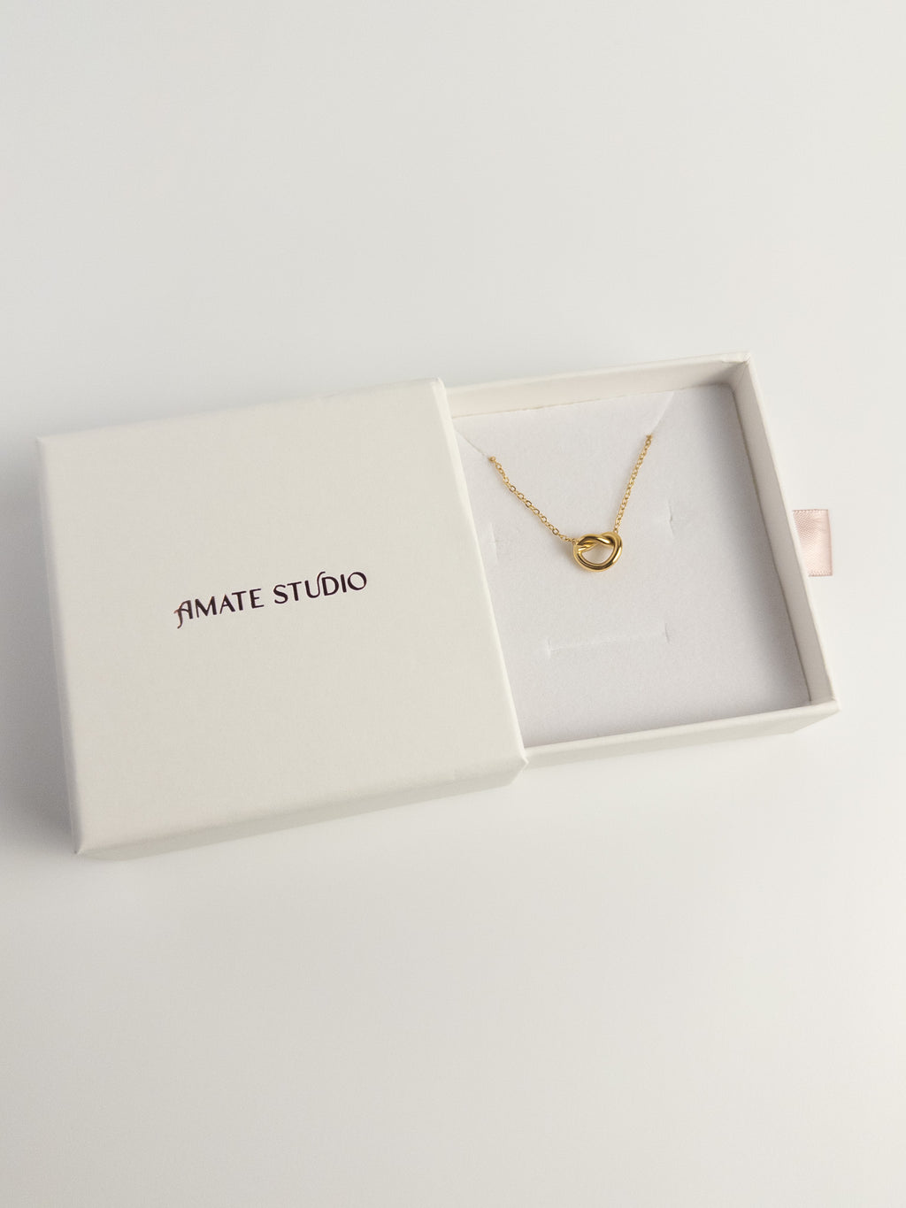 Grace Heart gold heart knot necklace inside Amate Studio drawer box with pink ribbon